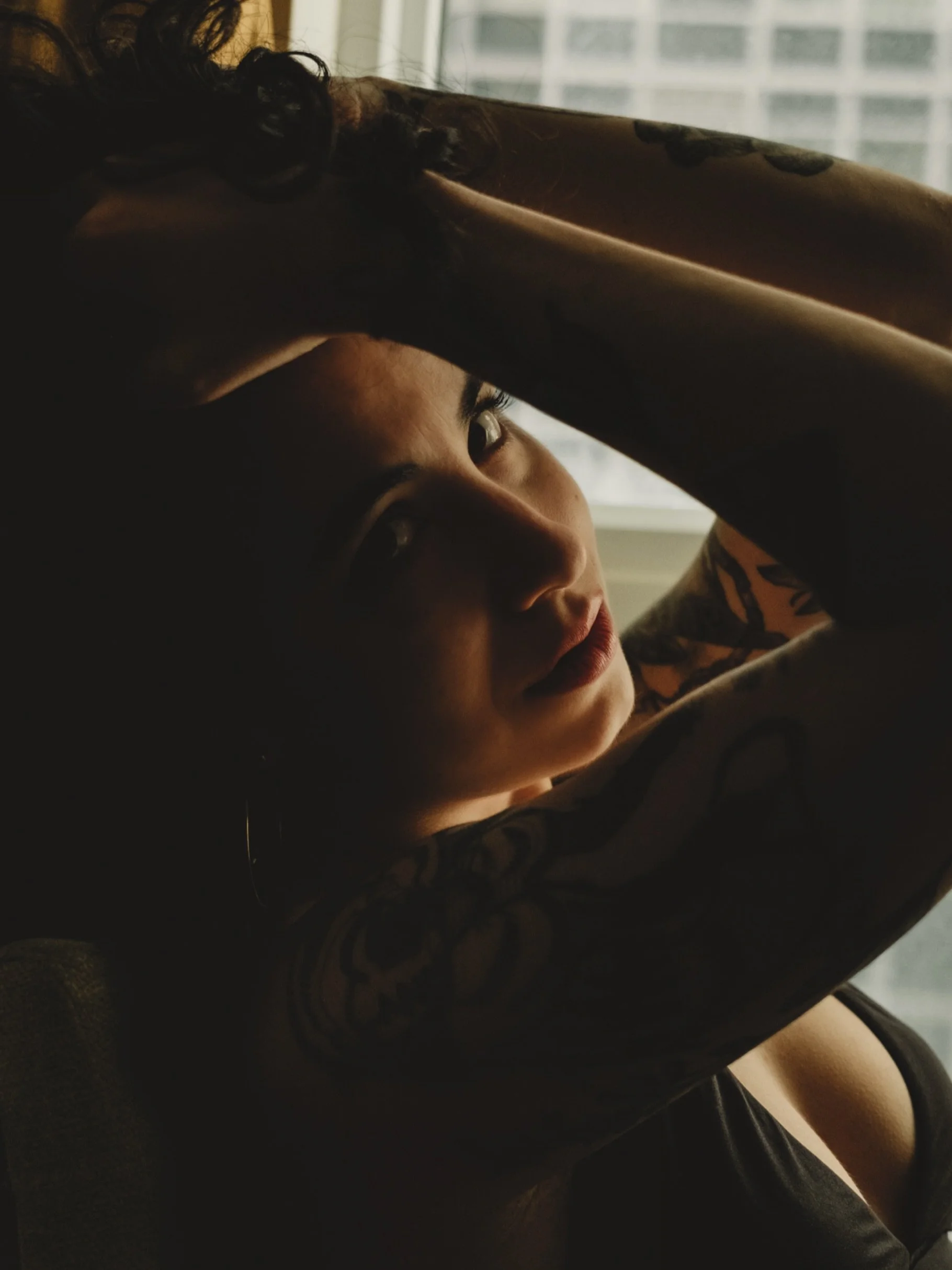Light does not just fall on skin.
It moves across it.
It finds the curve of a shoulder, the hollow beneath a collarbone, the soft edge where warmth turns to shadow.
This is what I am always chasing as a portrait photographer. Not a face. Not a pose. 