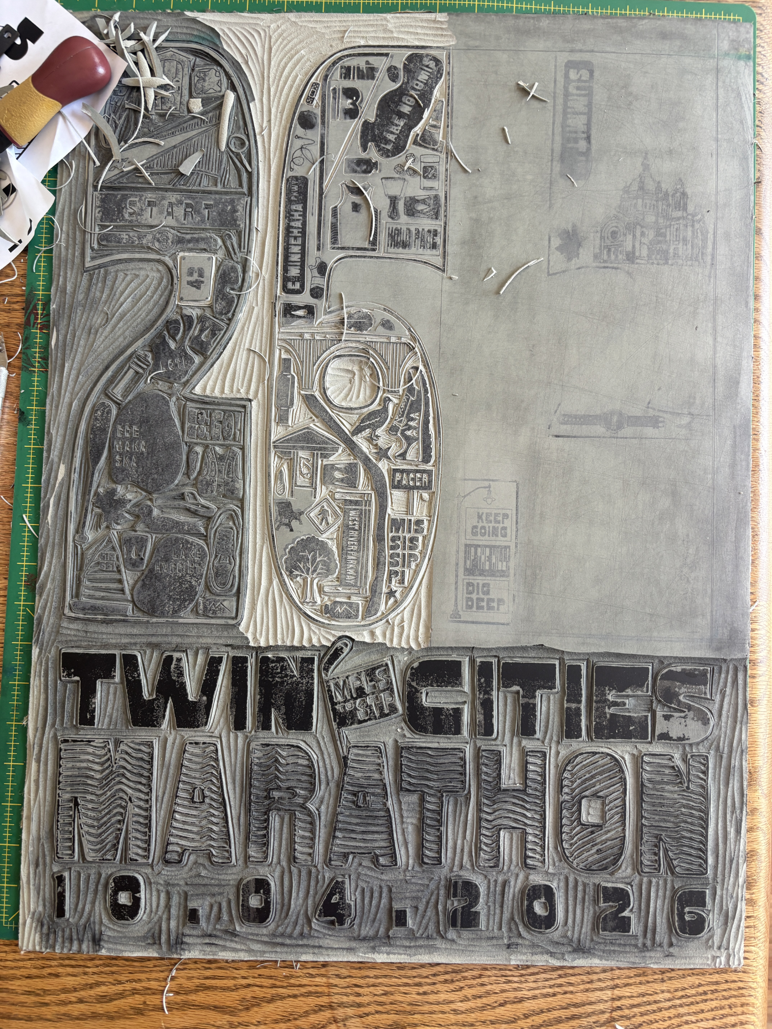 Carved linoleum block showing the full Twin Cities Marathon poster design before printing
