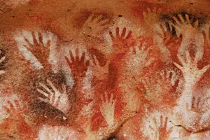 Prehistoric hand stencils on the rock wall at Cueva de las Manos, Argentina.