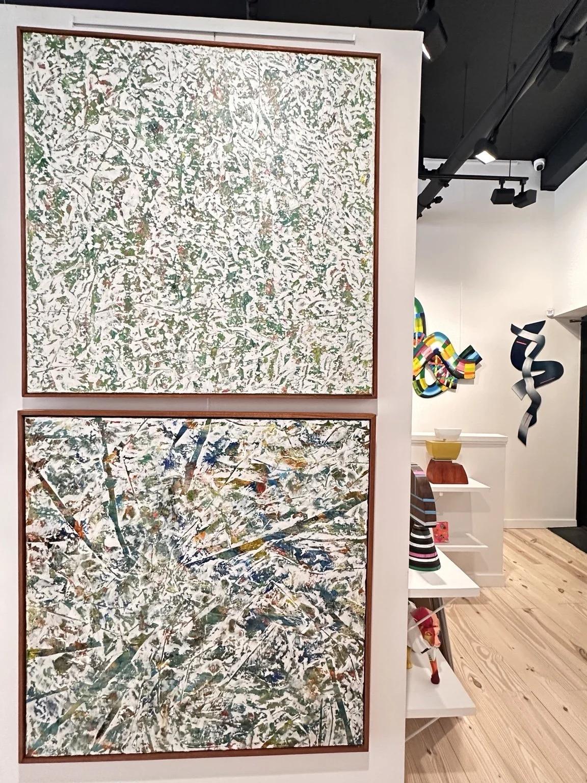 Two textured acrylic paintings displayed in J. Nunez Gallery, showing dense layered marks and raised paint surfaces.