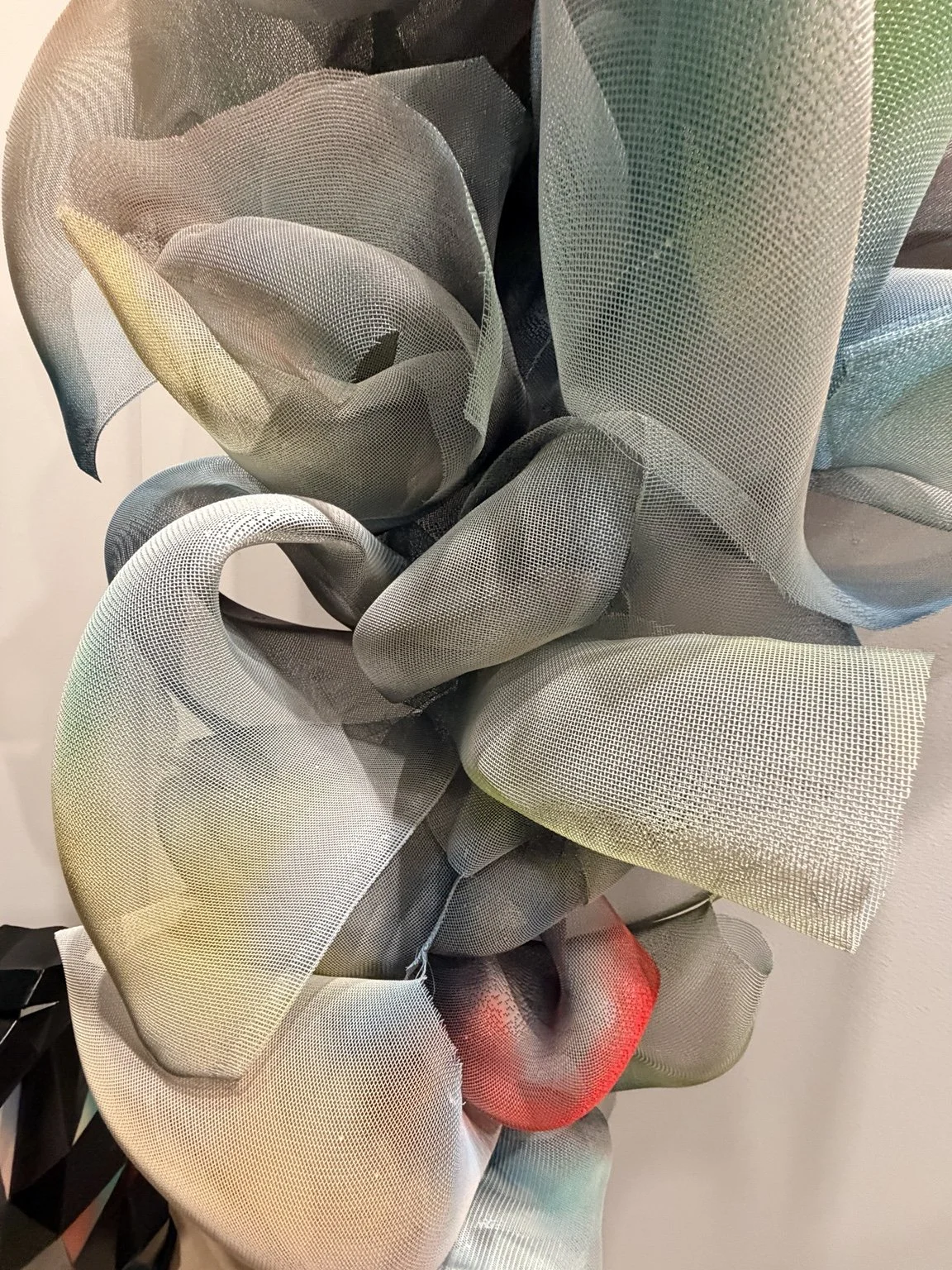 Close-up of layered translucent mesh folded into sculptural curves.