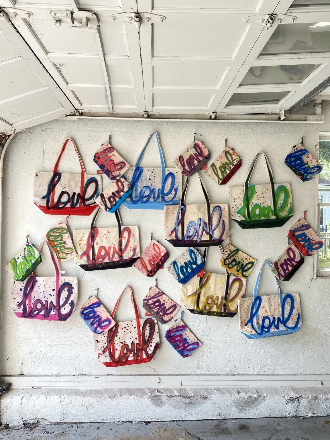 Limited-edition Love bags and accessories displayed on the gallery wall during the fundraising campaign.