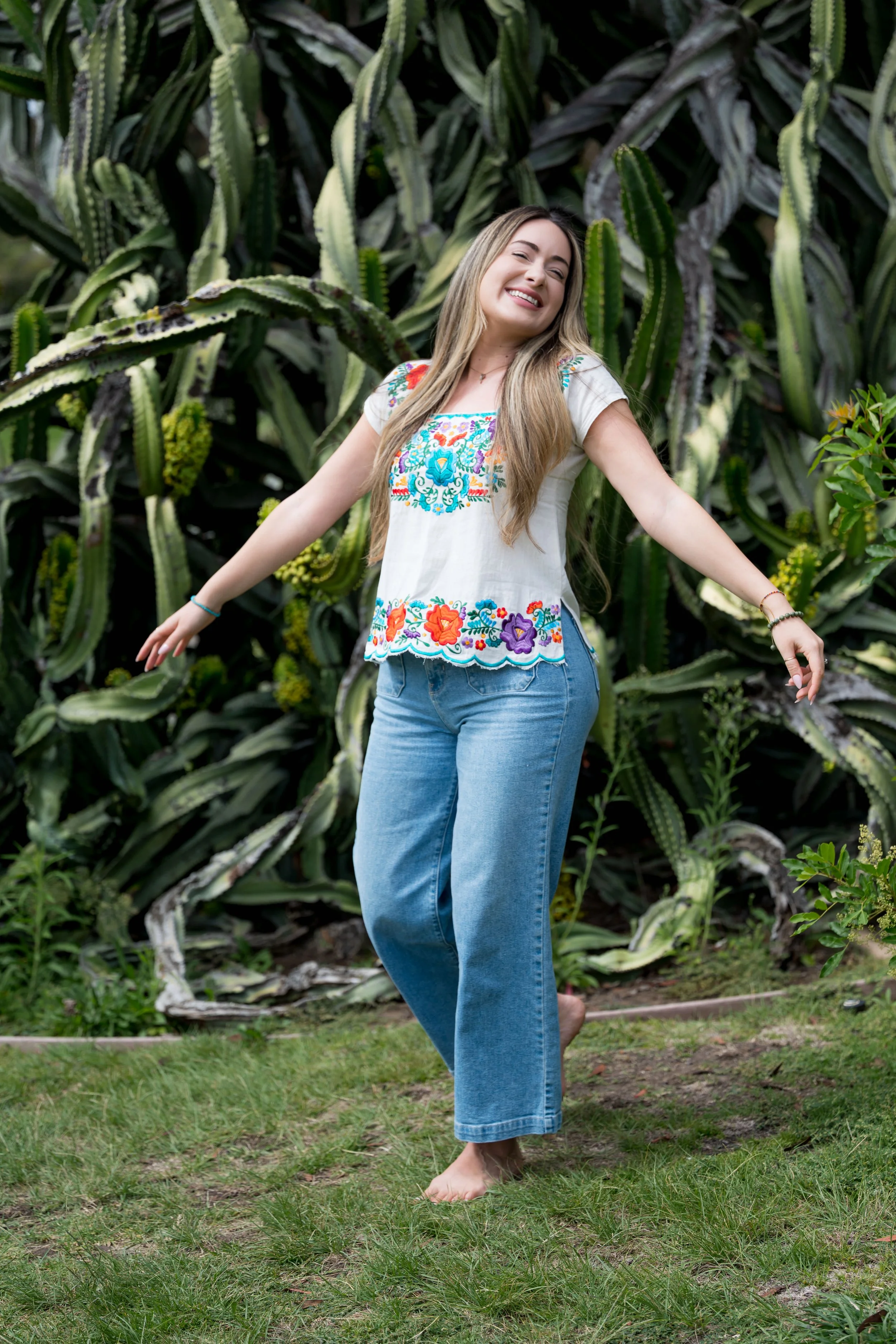 Woman embracing a feeling of joy and freedom in Balboa Park's cactus garden during a San Diego photoshoot