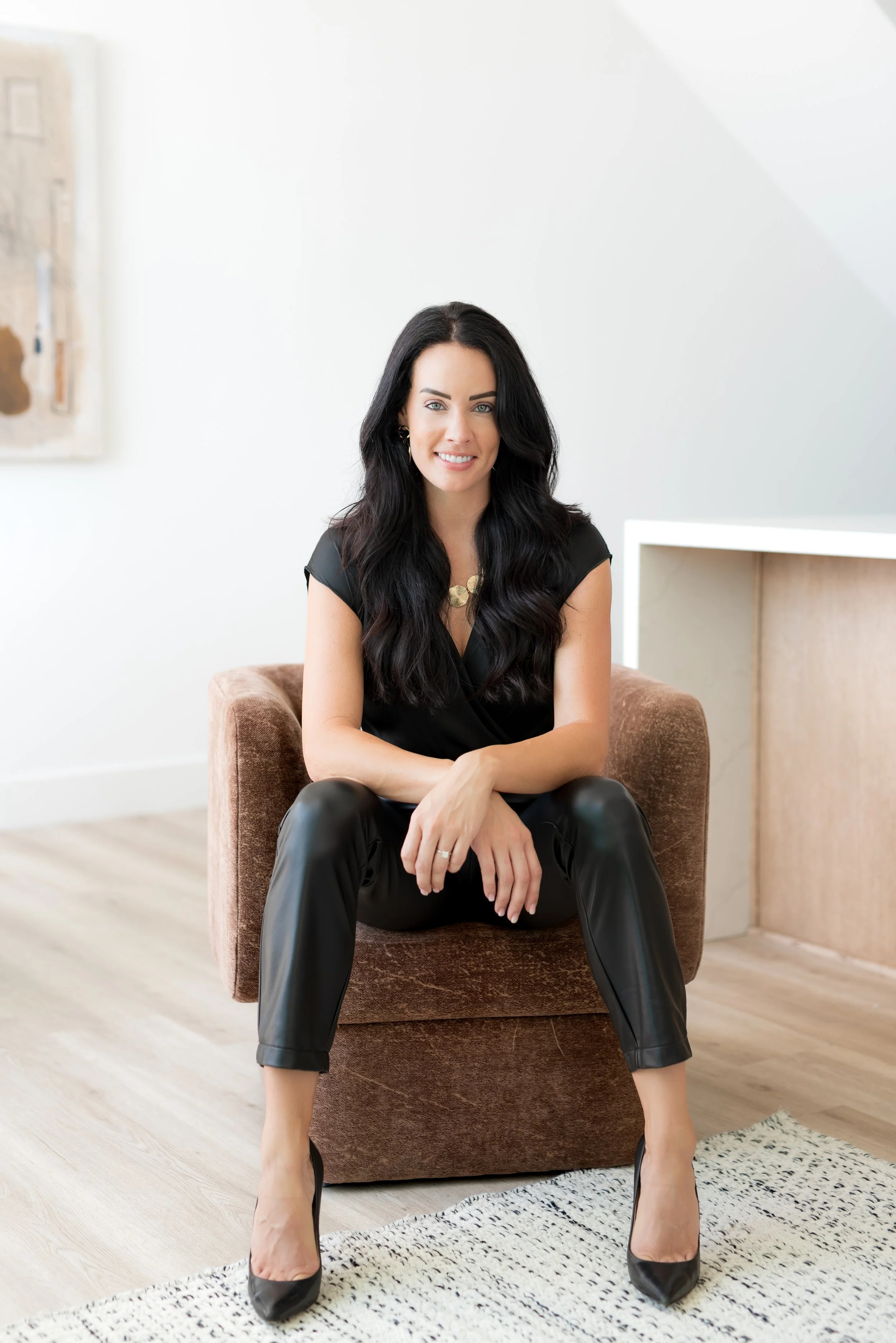Confident realtor posing in a chair during her San Diego Real Producers magazine photoshoot