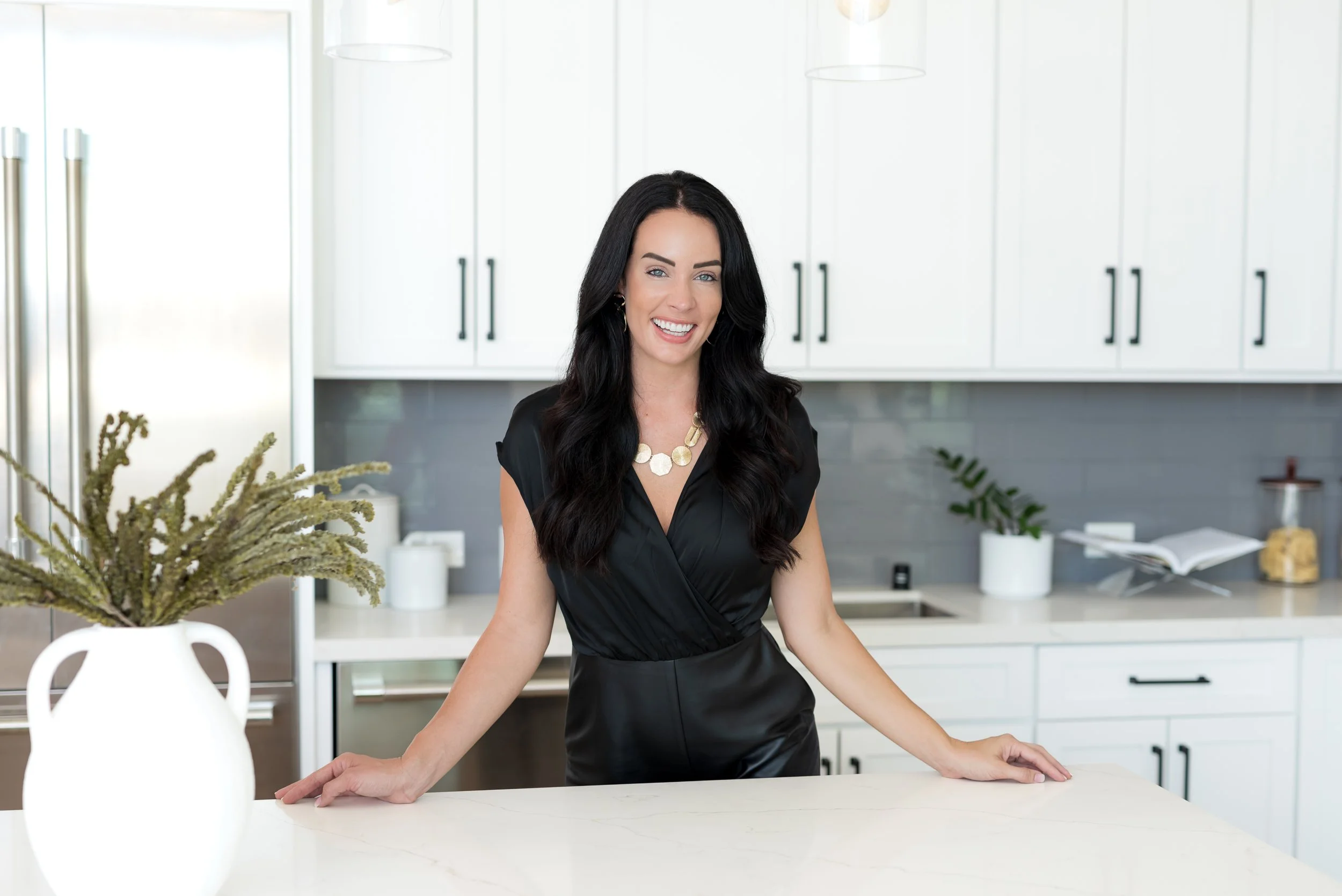 San Diego realtor smiling in her kitchen for a San Diego Real Producers magazine feature photoshoot