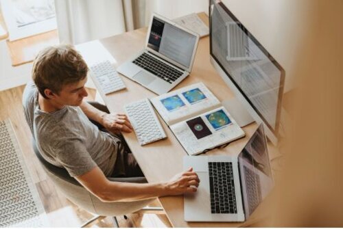 a person sitting at a table using a laptop computer