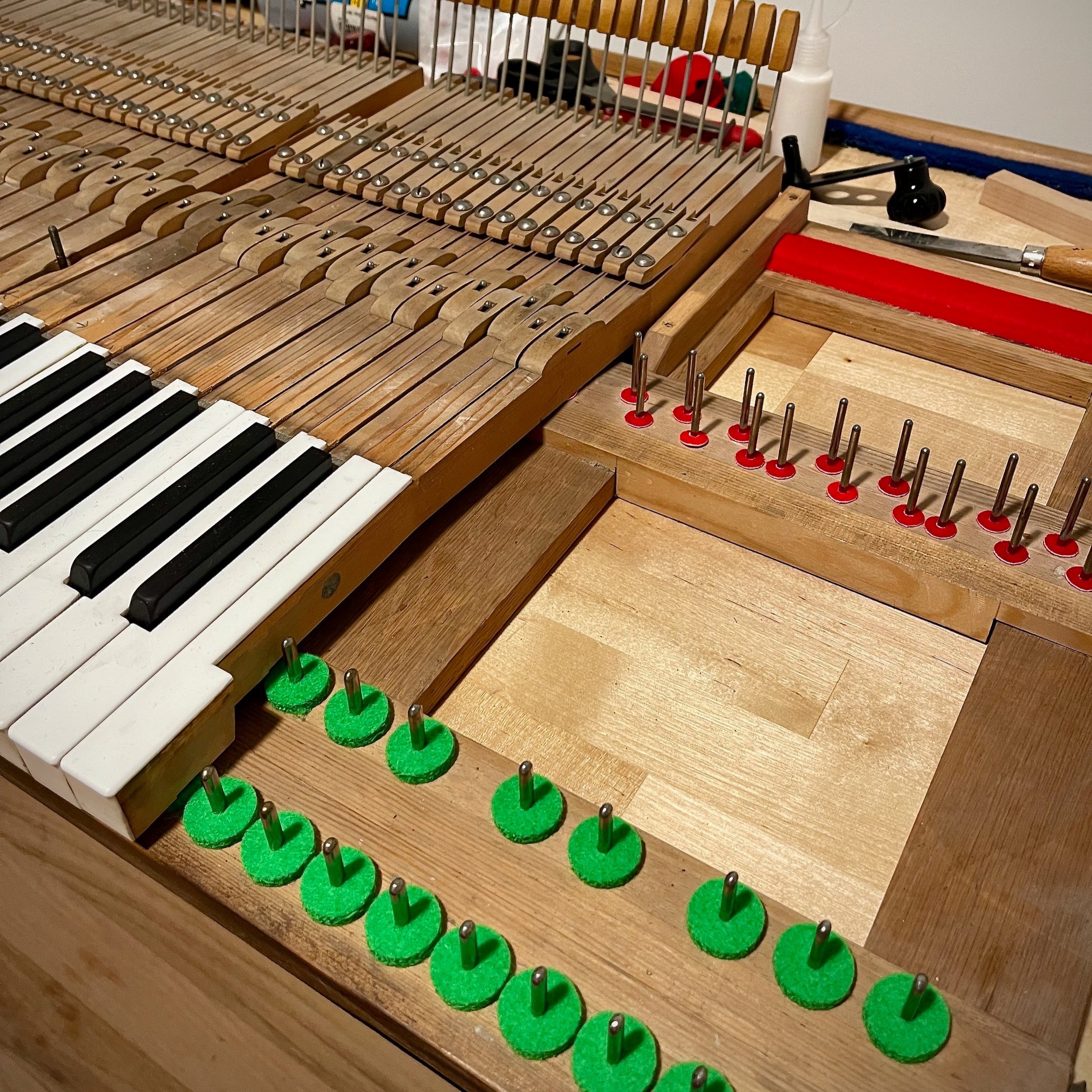Seen here are new felt, paper, and cardboard punchings under the keys, as well as completely new red key rest felt under the ends of the keys.