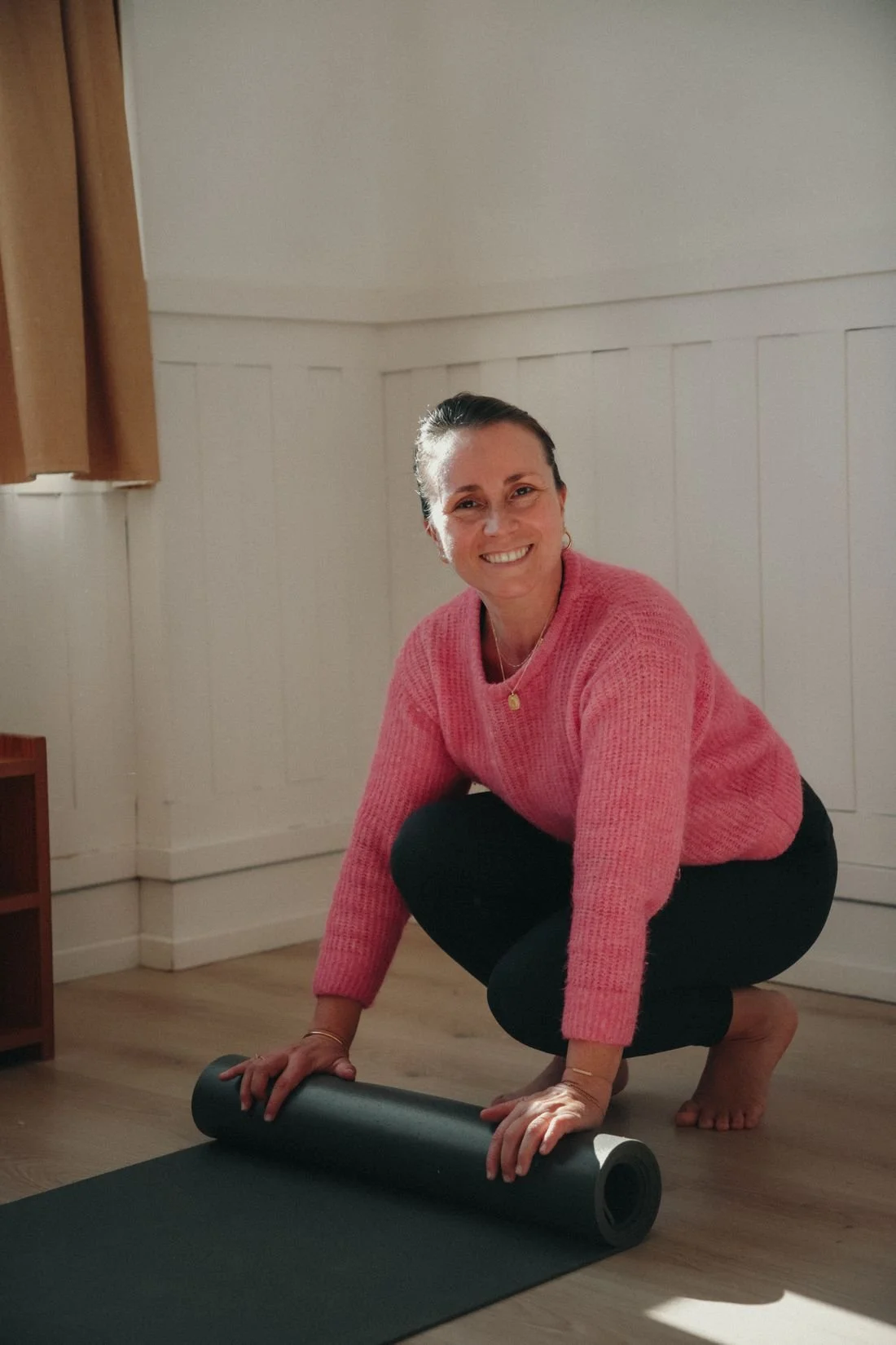 Pauline Bellocq rolling out a yoga mat in soft morning light