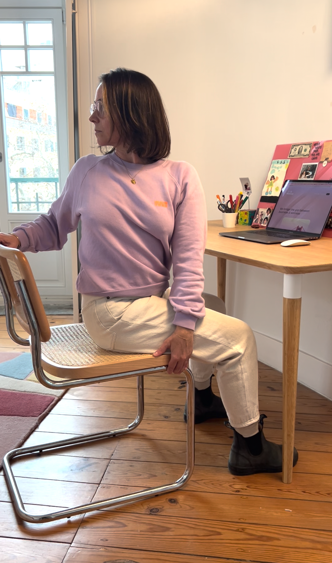Pauline demonstrating a seated twist on an office chair at a desk