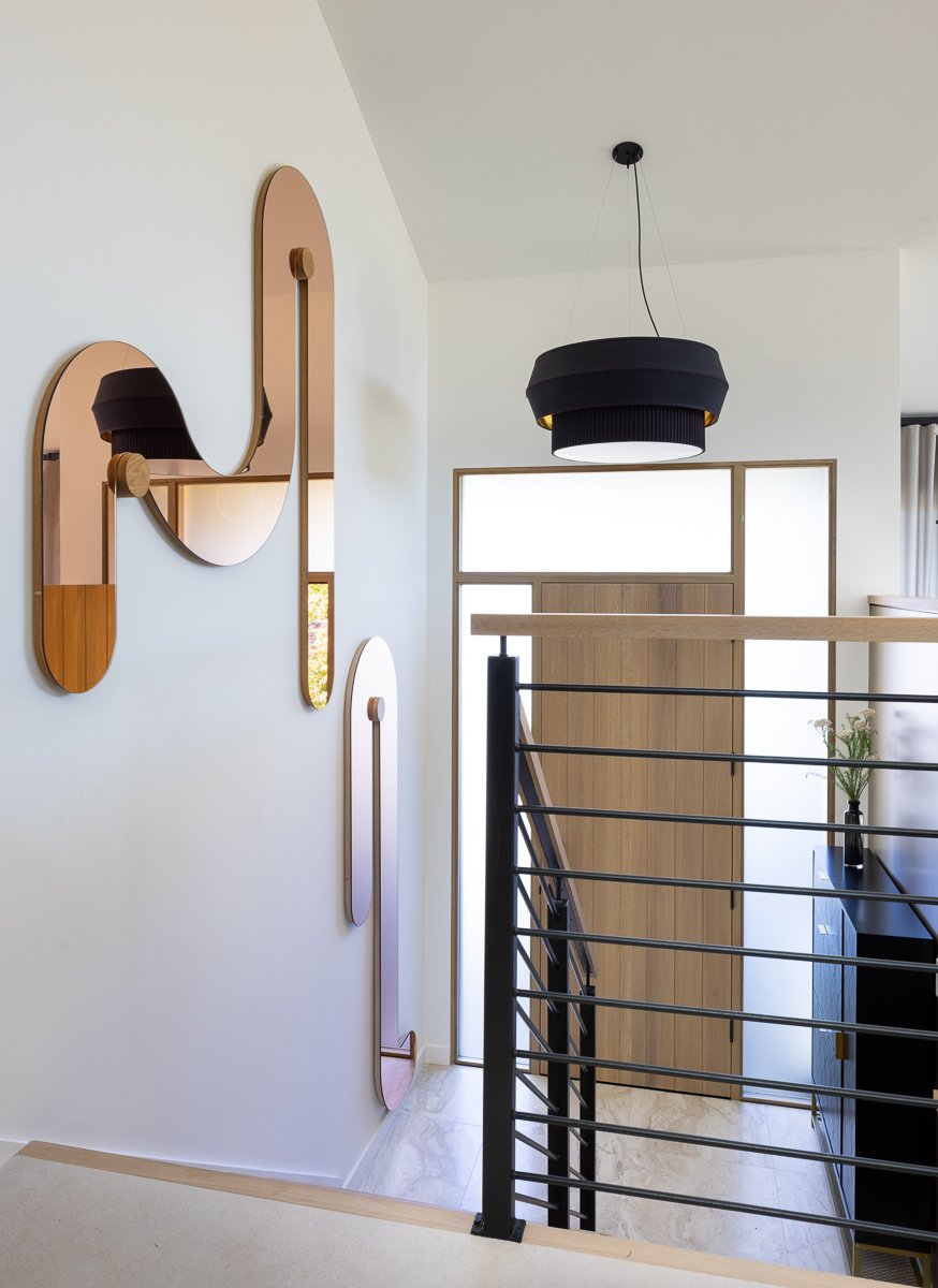 Entry stair case with art work and pendant lighting