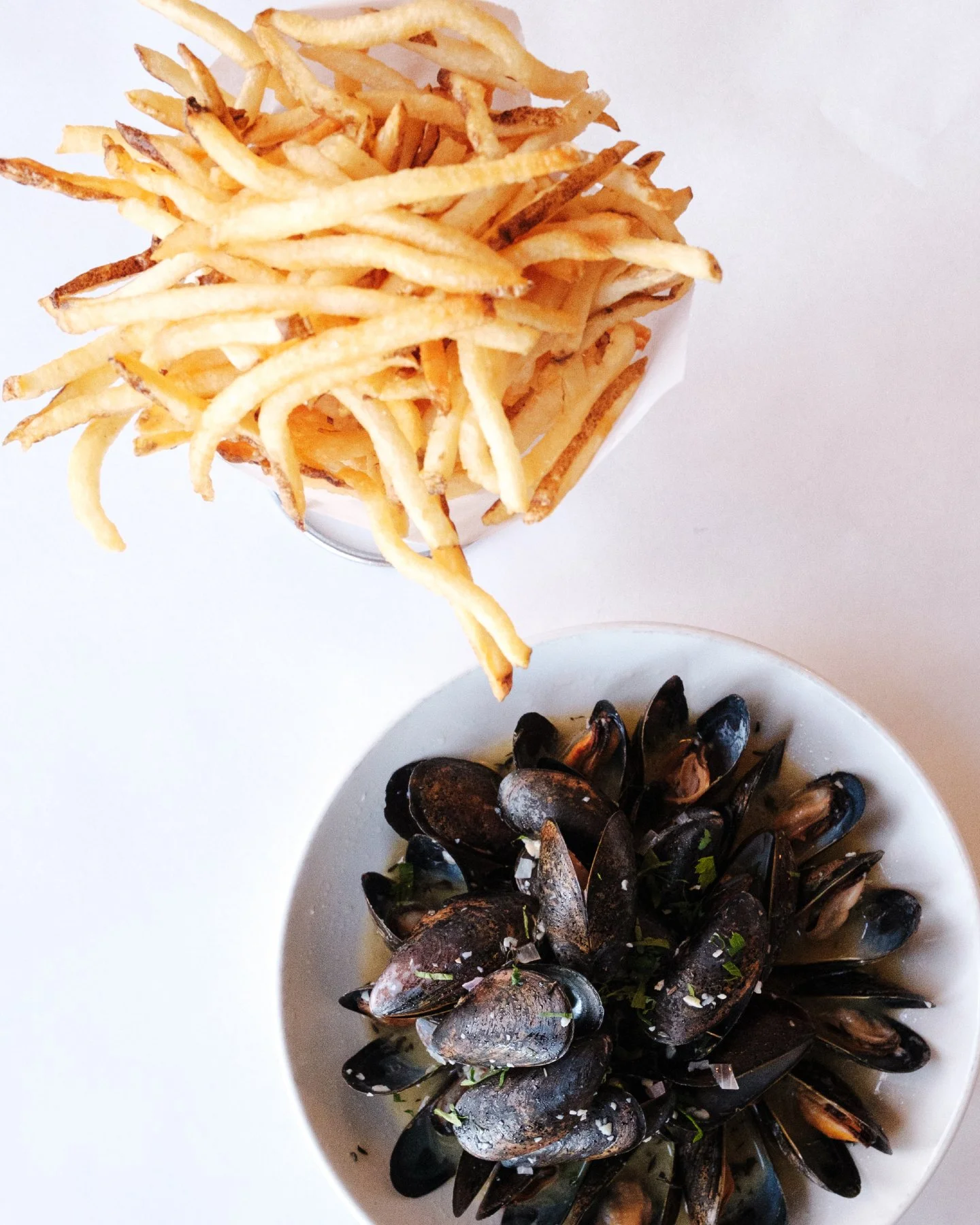 Golden hour, a glass of wine, and a steaming plate of Moules Frites 🍷✨

Our Prince Edward Island Moules Frites are simmered with garlic, white wine, butter, thyme, and shallots, then served with crispy frites for the ultimate cozy-yet-classic patio 