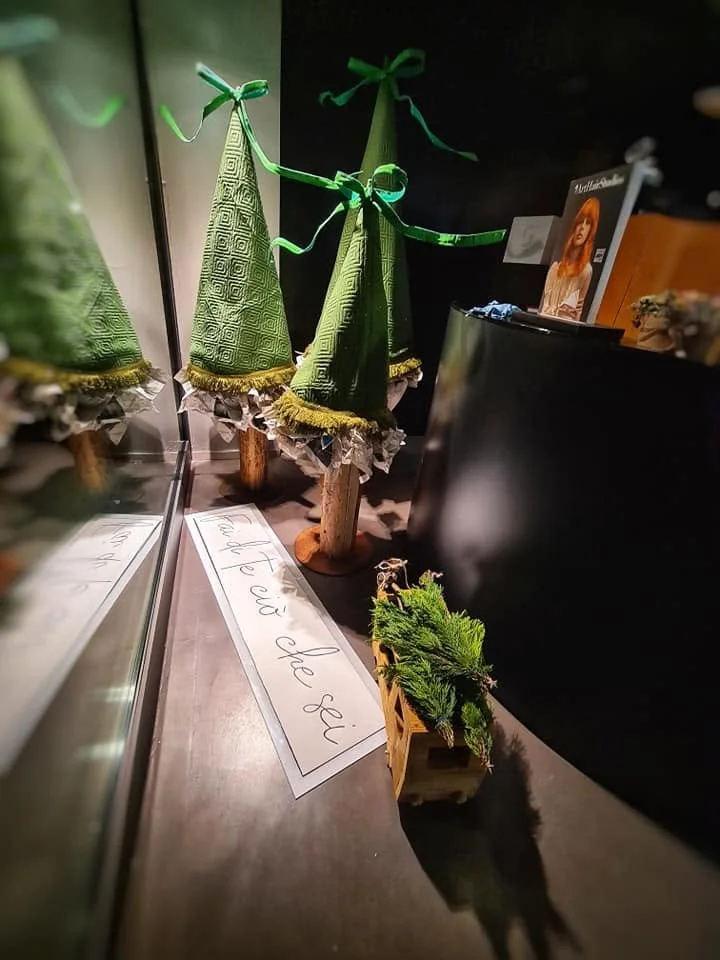 Decorazioni natalizie con alberi di Natale di stoffa e un piccolo albero di abete in una scatola di legno.