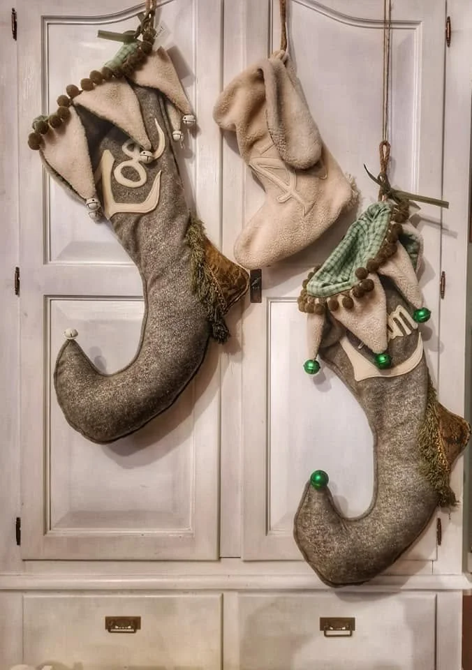 Stivali di Natale decorativi appesi a un armadio, in forma di calzature a sock e comete