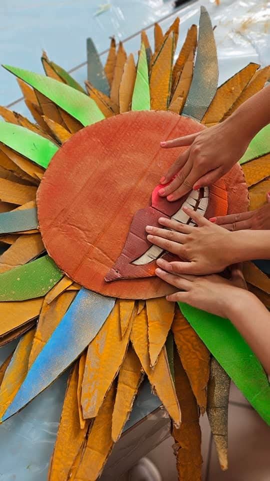 Persone che creano un fiore di carta con foglie colorate