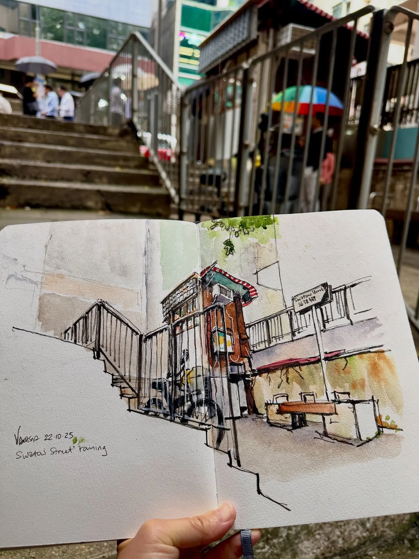 Last week, we enjoyed a perfect clear blue sky for our lunch sketch, but this week brought drastic changes in the weather, with much cooler temperatures and drizzling rain. A few of us sought refuge inside cafes or under canopies. However, my origina