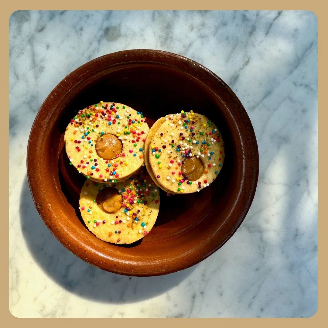 A cute couple of bites to end your meal 🥰

Semolina fennel sandwich cookies filled with a ricotta whey caramel very reminiscent of a dulce de leche, and topped with rainbow nonpareil sprinkles and fennel pollen. They're perfectly crunchy and creamy,