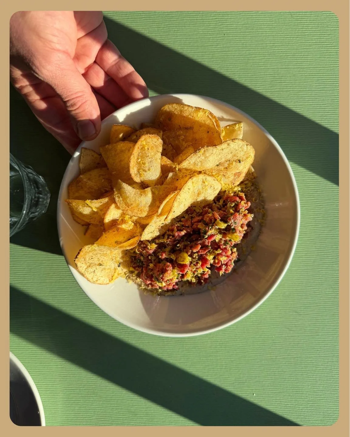 Steak tartare with caper dusted potato chips for scooping makes a perfect shareable starter for you and some hungry carnivorous friends. Served with a swoop of anchovy aioli, beef tenderloin tartare gets mixed with some Calabrese chili, shallot, pick