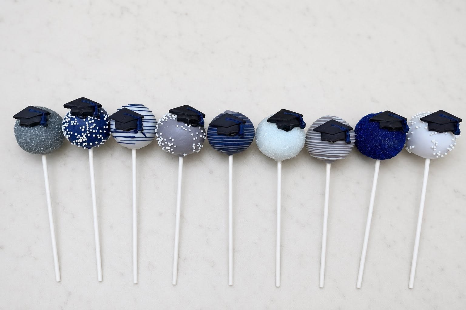 Silver, Navy, and White Graduation cake pops in stand