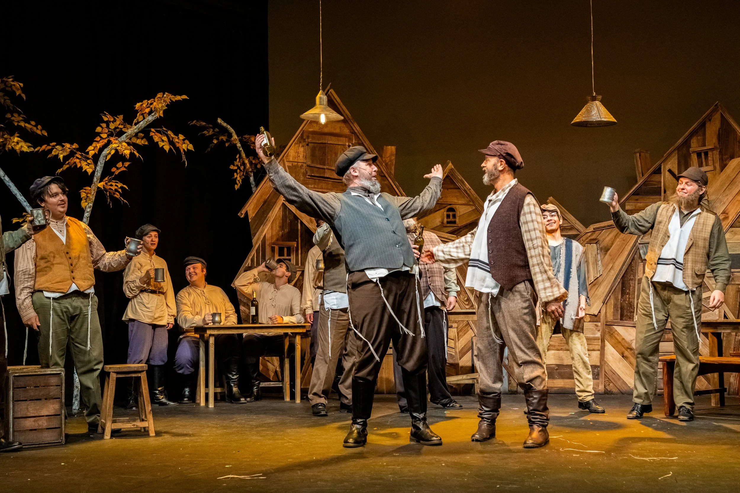 Cast of Fiddler on the Roof in village costumes onstage.