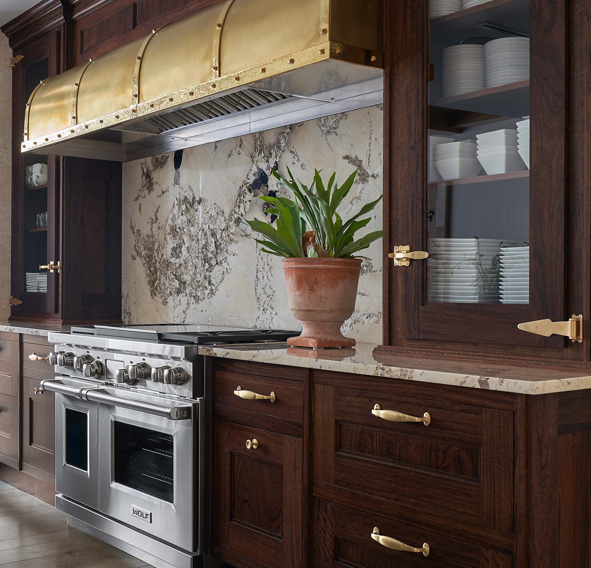  Modern comfortable contemporary kitchen in Museum Tower high-rise in downtown Dallas, Texas featuring brass hood range and marble countertops  