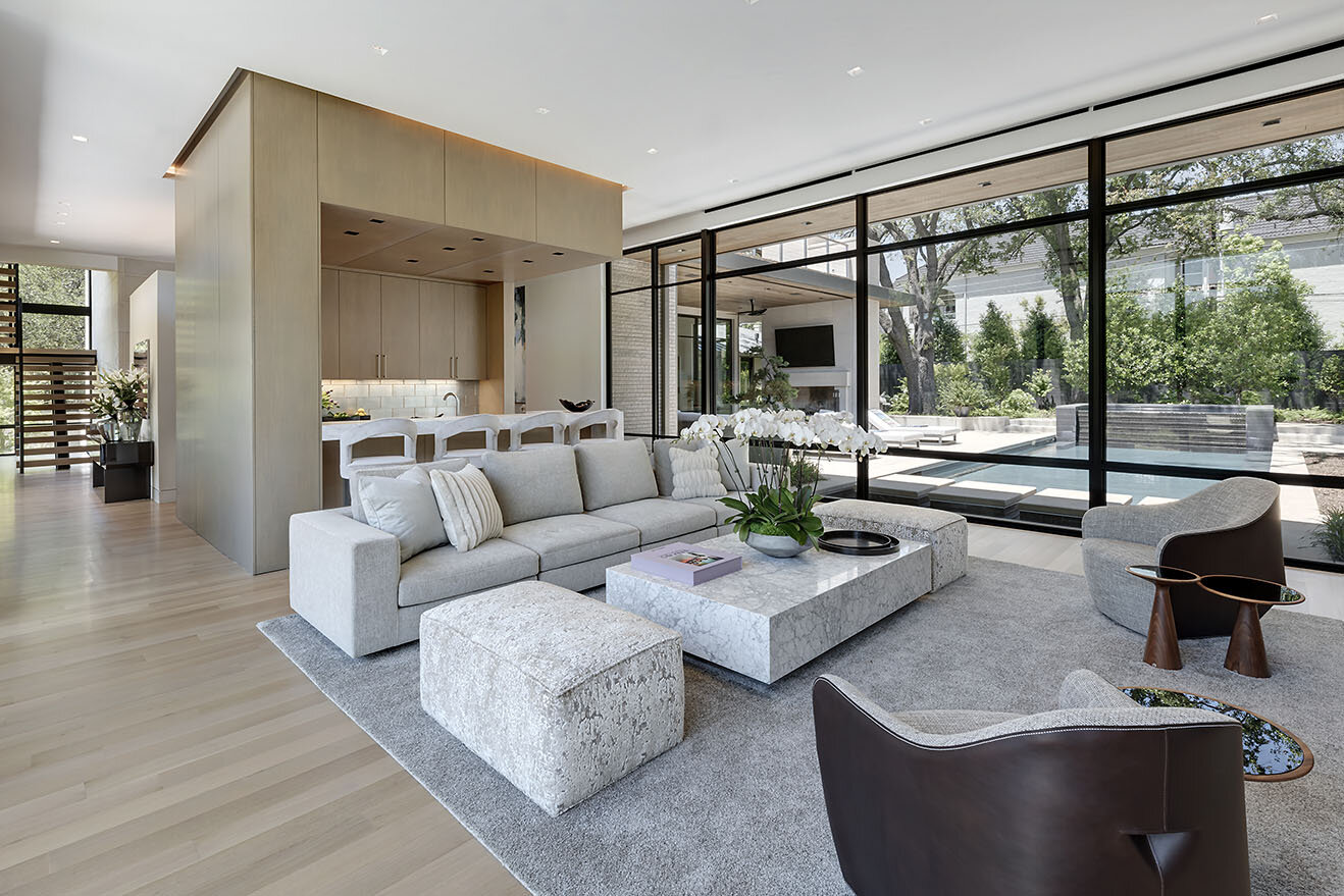  Modern comfortable contemporary home in Preston Hollow Dallas Texas featuring a fluid connection between interior and exterior with wall of glass windows and views of pool terrace 