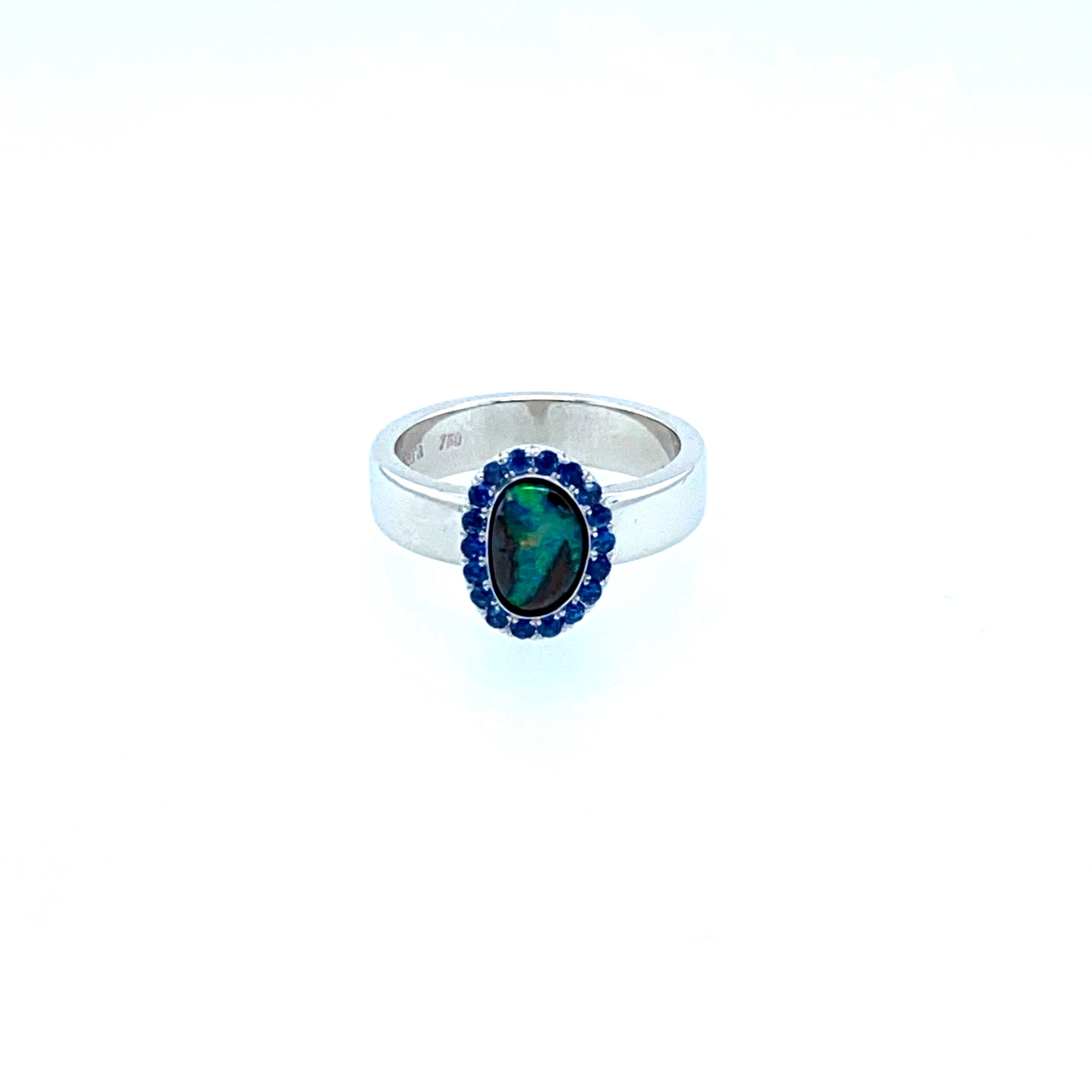 A Queensland boulder opal set in 18ct white gold with a Ceylon sapphire halo.  This centre stone is a free form opal which you can see in its unusual shape.  (Currently Available)