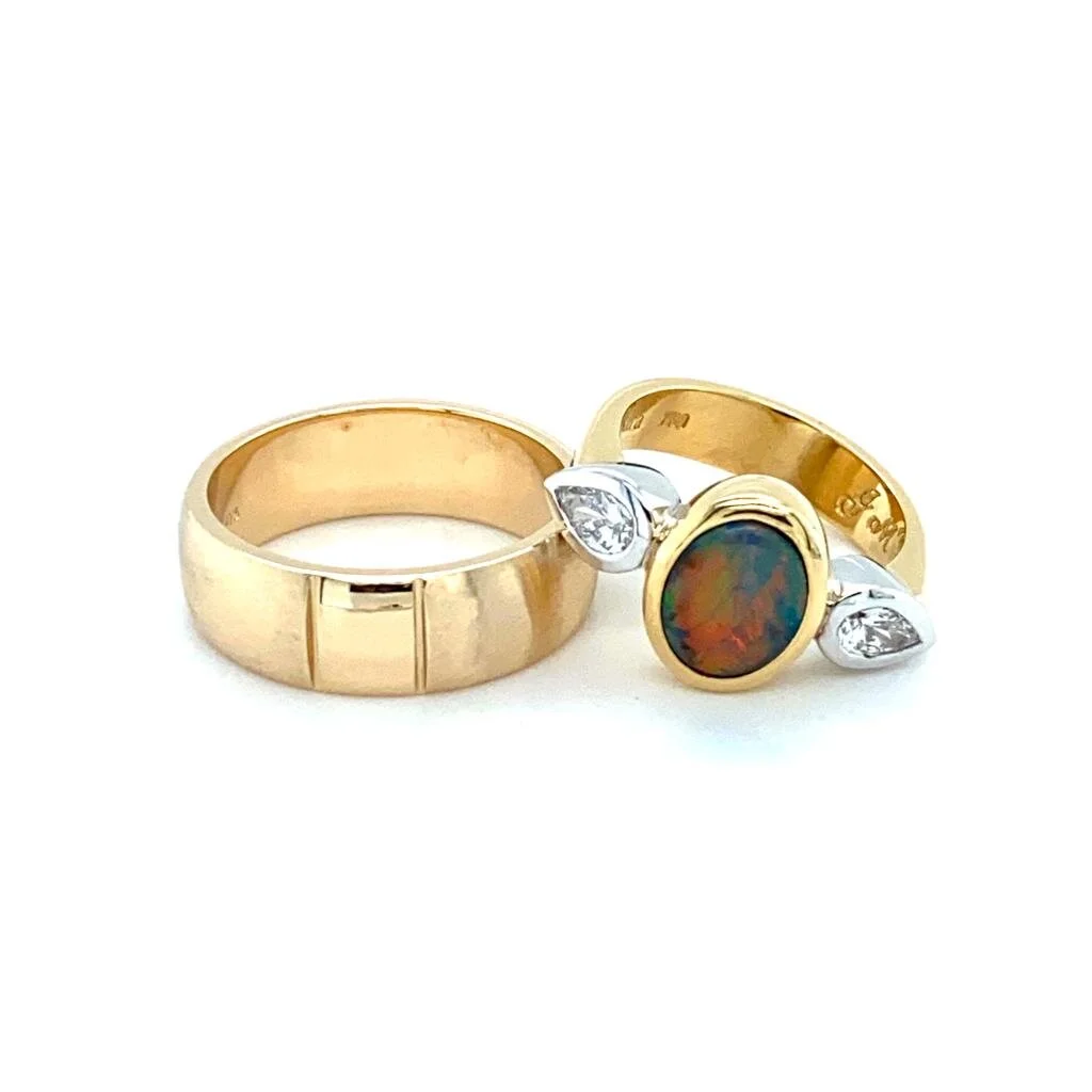 A black opal wedder created in 18ct gold with pear shape diamonds on the side.