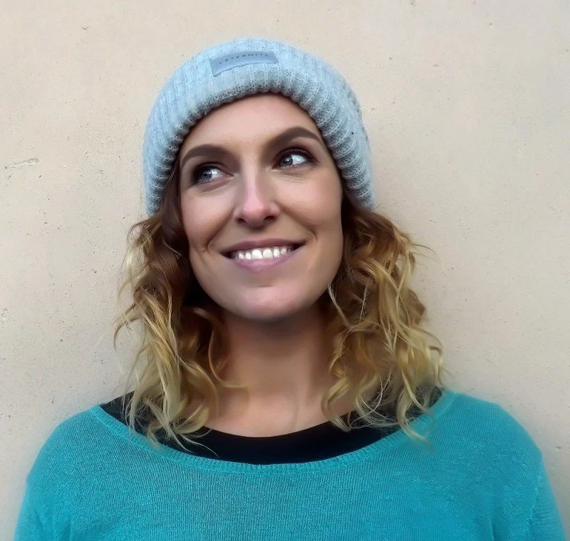 Photograph of Emily Bratt in beanie and jumper smiling
