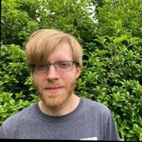 Close-up of a person's hand pressing on guitar strings on the fretboard.