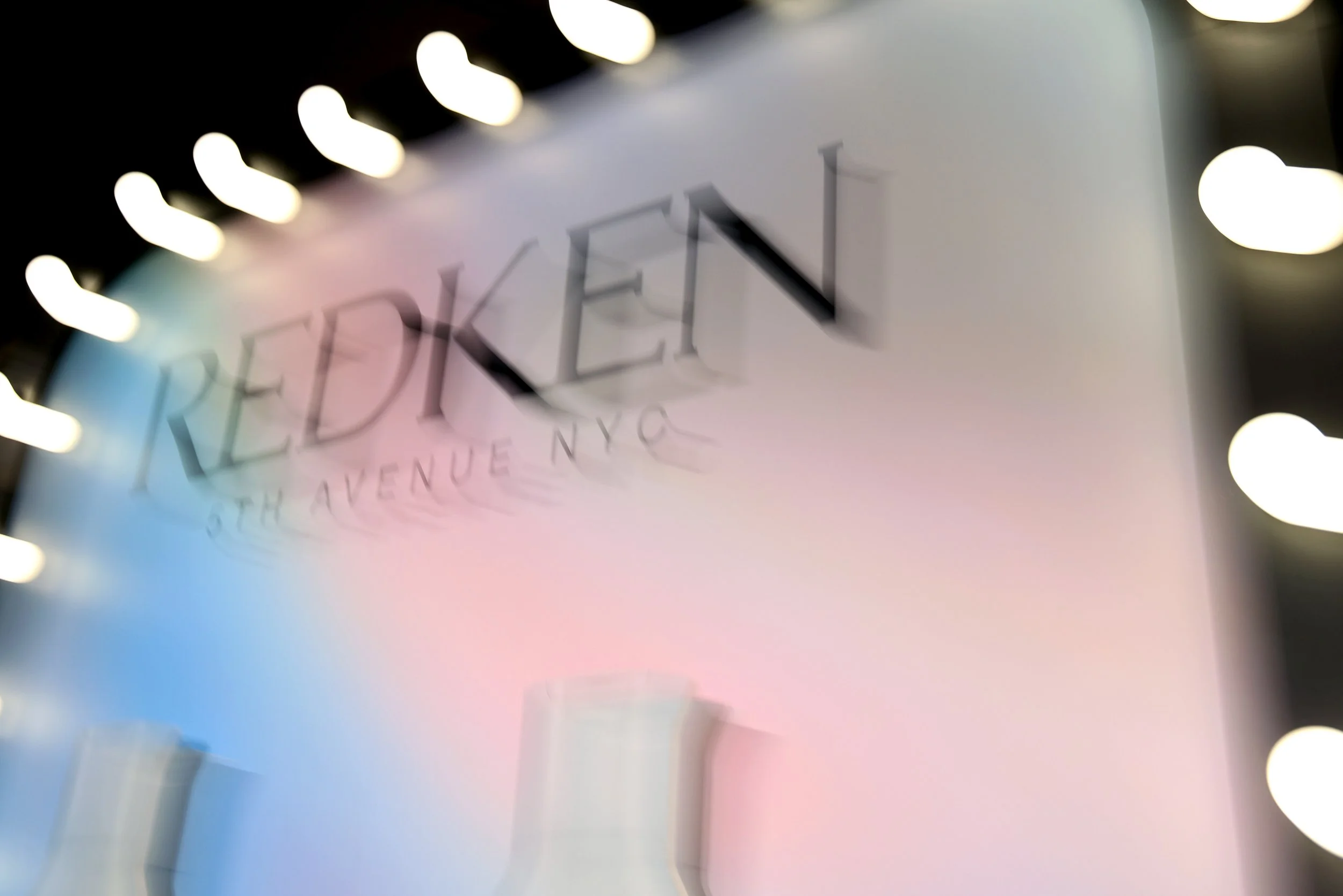 Blurred sign with the word 'REDEFINED' and part of the text indicating a location on 5th Avenue in New York City.