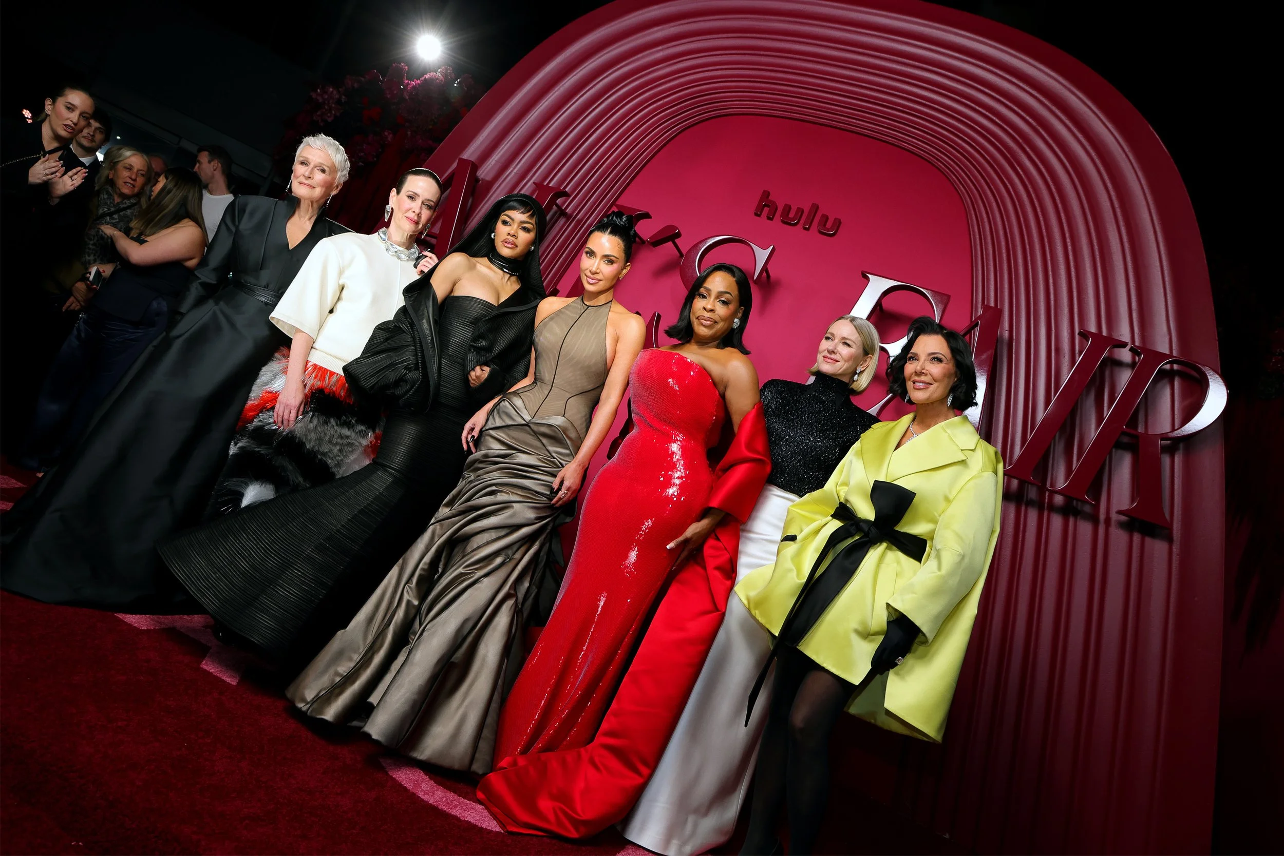 Group of women at a red carpet event in front of a Hulu and FX backdrop, dressed in elegant and fashionable evening wear.