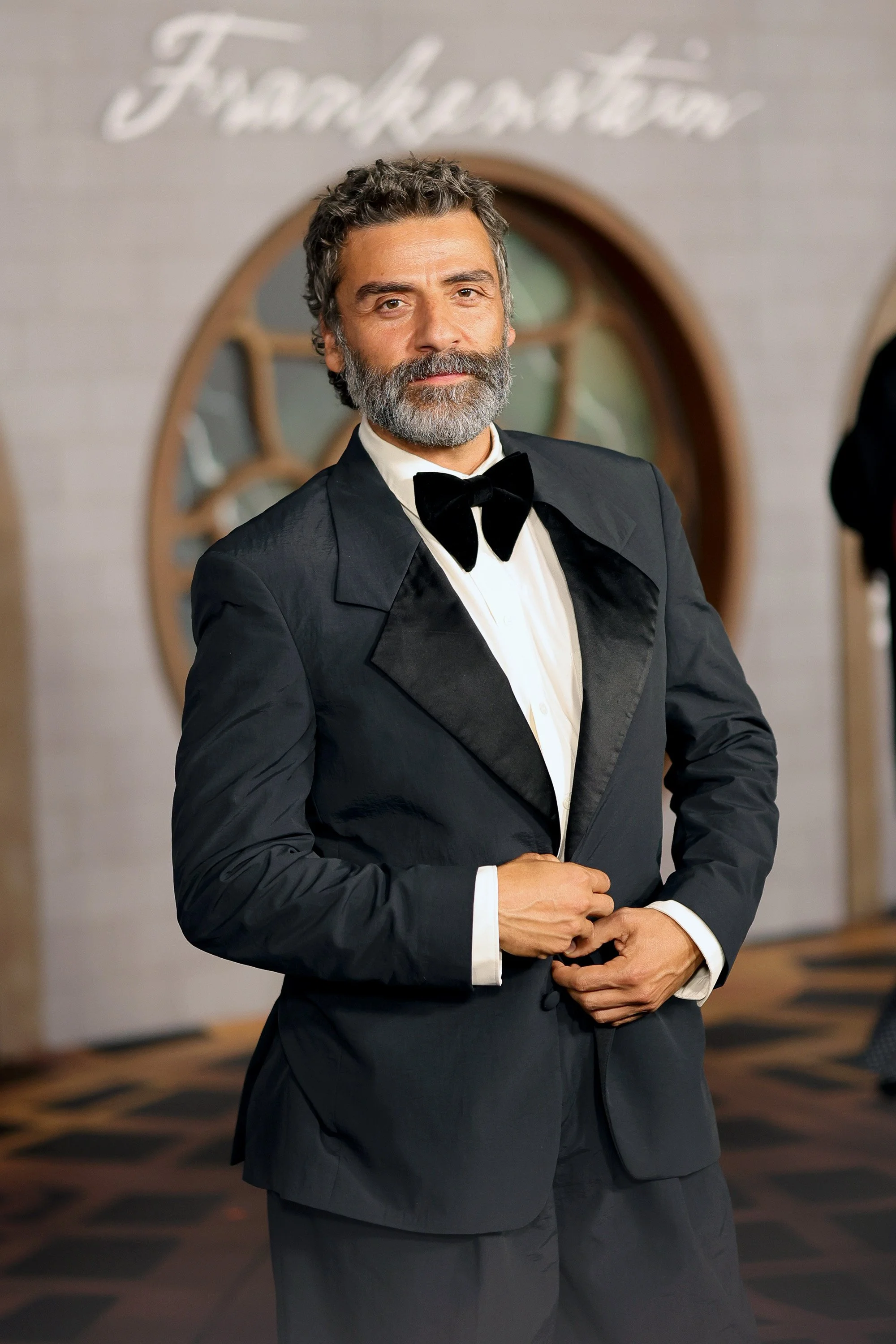 A man with gray hair and beard wearing a tuxedo and bow tie at a formal event.