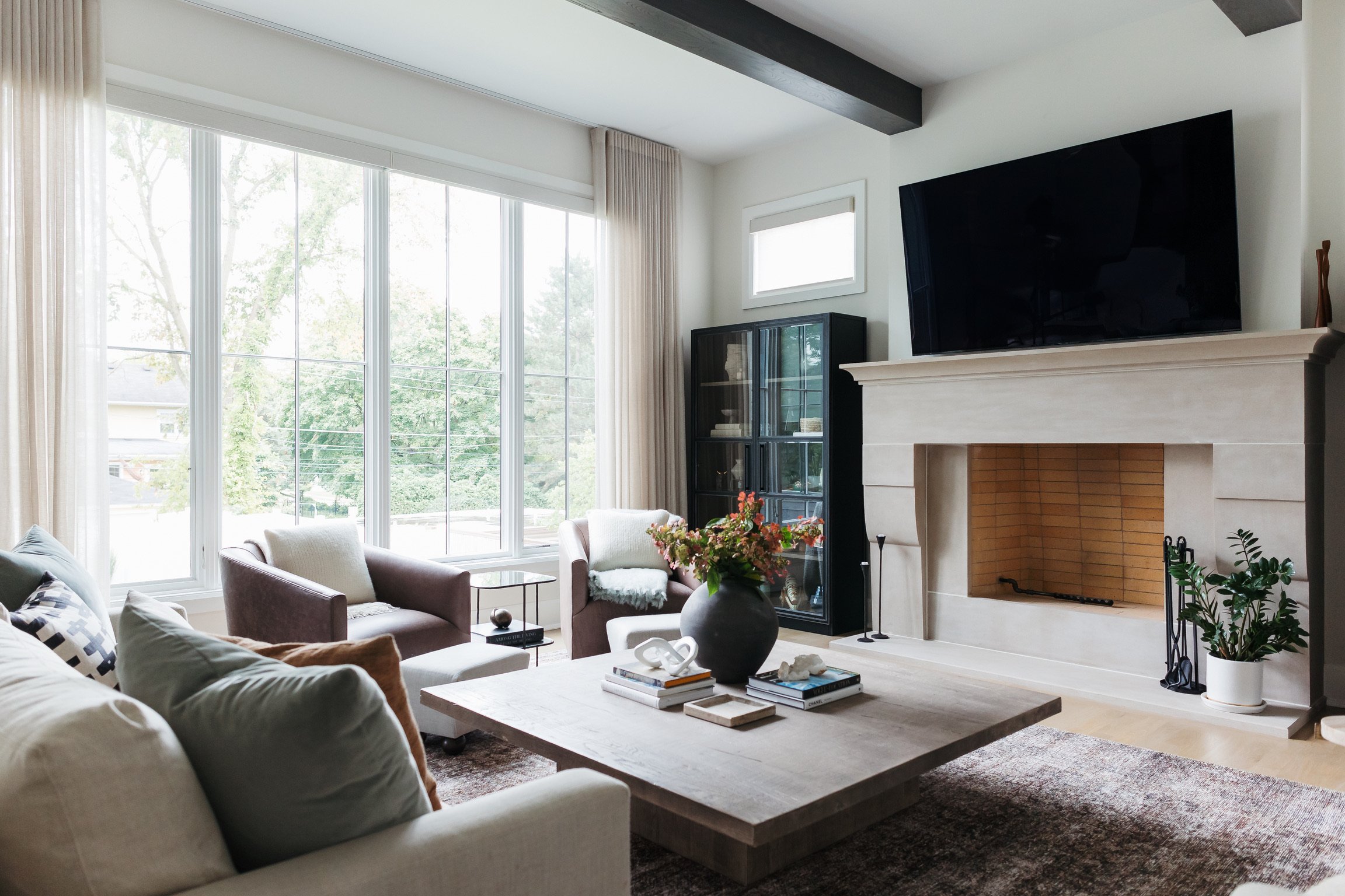 artesian-designs_family-room-limestone-fireplace-beams.jpg