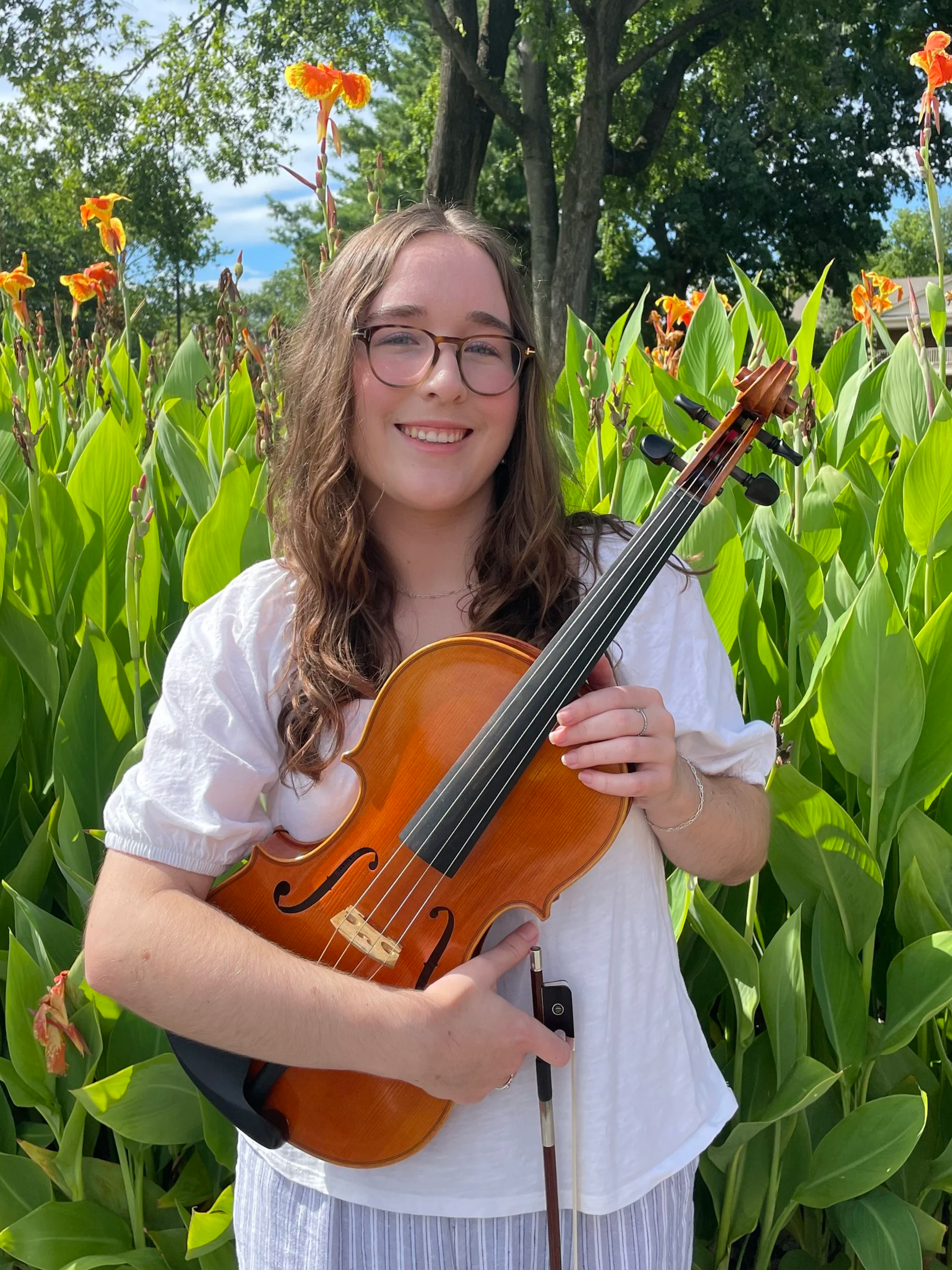 Brown hair girl with glasses in a white shirt holding a viola