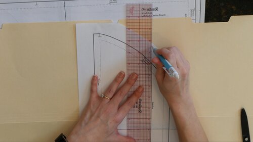 Extend the grainline of the pattern to both ends of the paper.