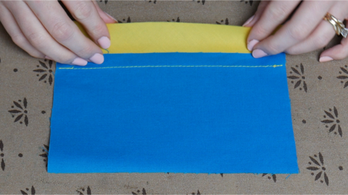 Fold the bias binding over the raw edges of the seam allowance.