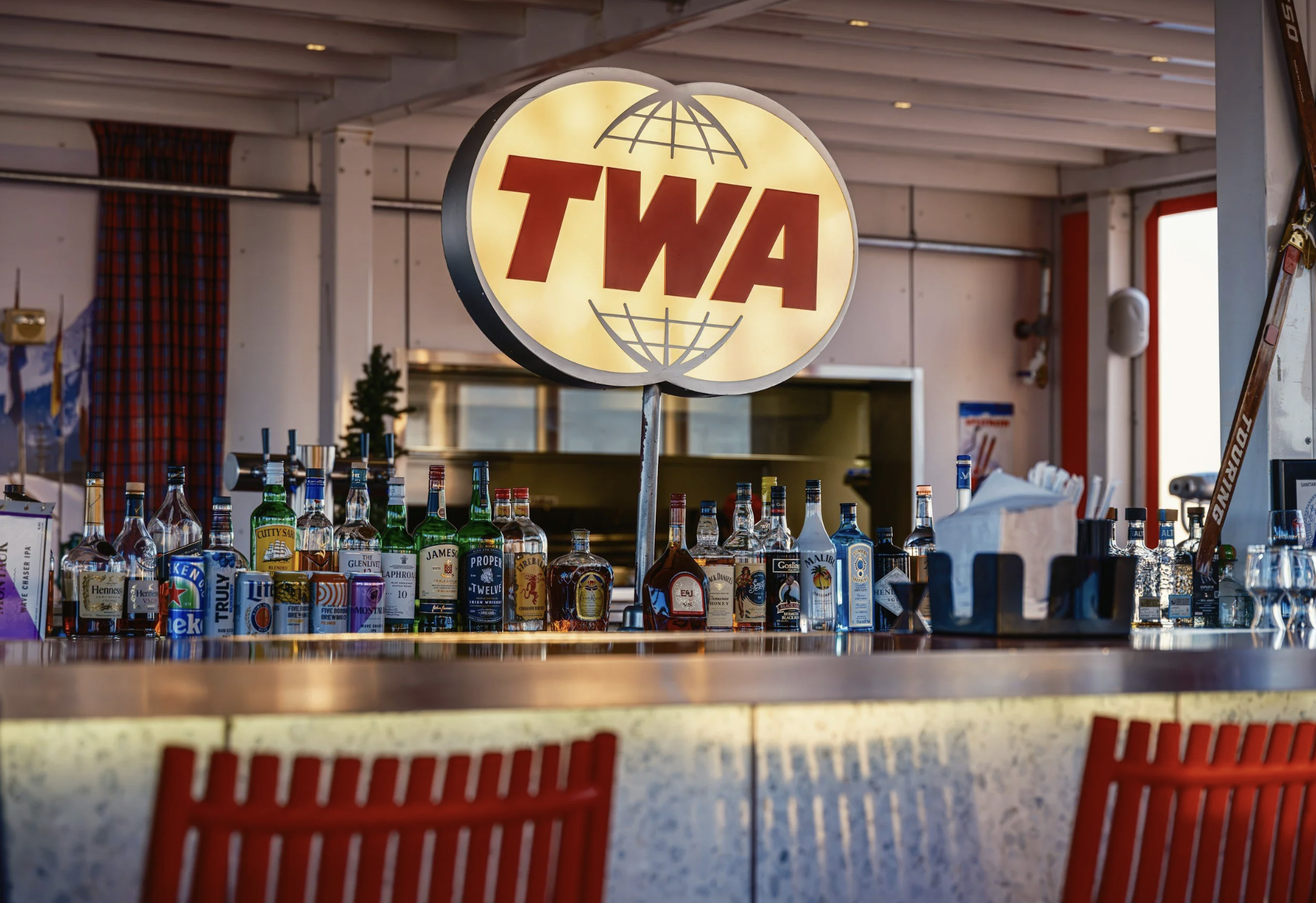Airport bar with a TWA sign, symbolizing a relaxed travel experience made possible through thoughtful trip planning.