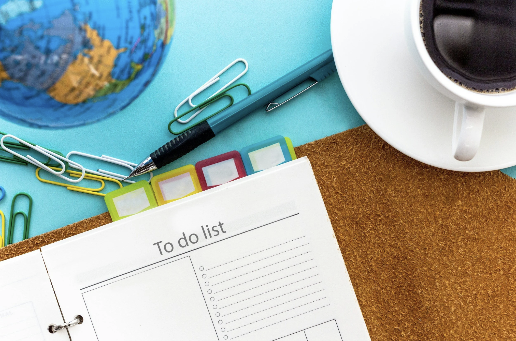 Travel planning workspace with travel essentials organized to prepare for an upcoming trip and avoid common travel planning mistakes.