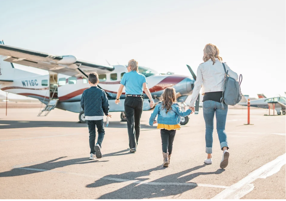 Family walking toward an airplane, representing personalized family vacation planning and leisure travel services.