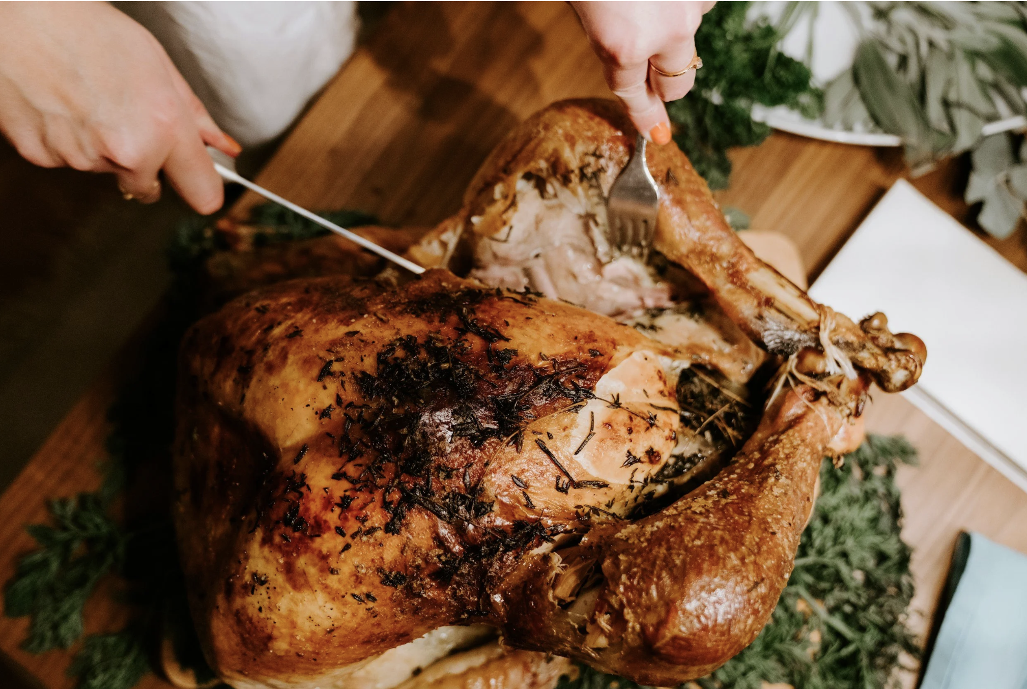 Roasted Thanksgiving turkey being carved, representing the start of the busy holiday travel season and family gatherings.