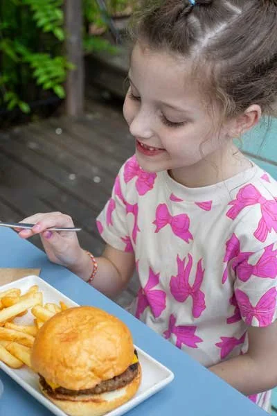 Child enjoying her cheeseburger with fries