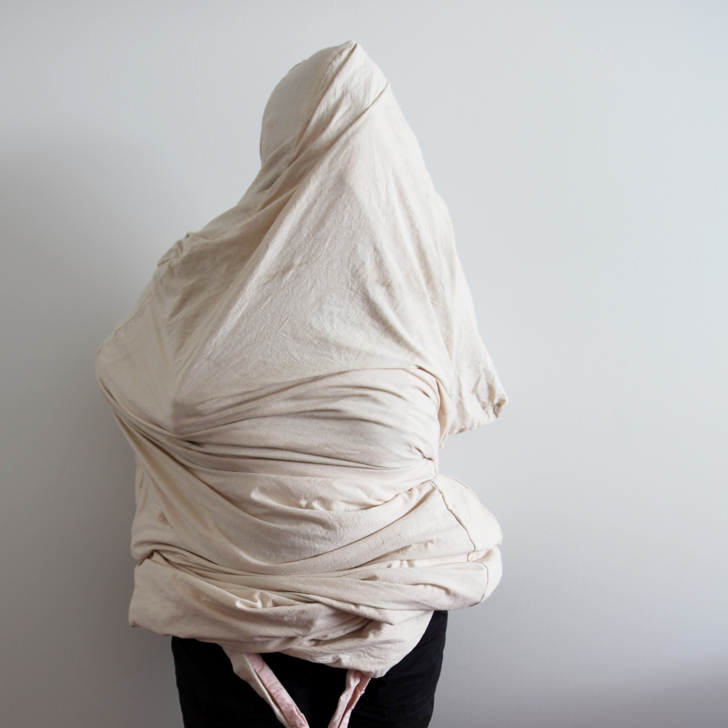 Person with their head and body enclosed in cloth bag.