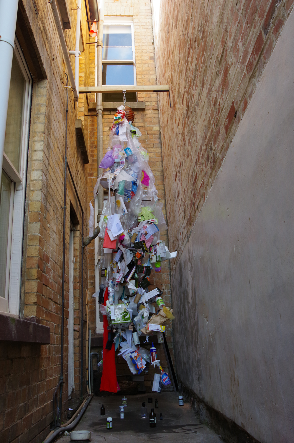 Photo of entire work, ribcage hanging at second story height with rubbish spilling out of it and hanging all the way to the ground 