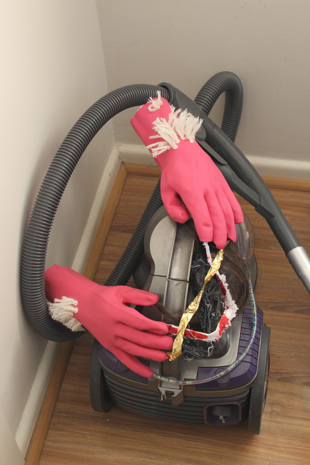 Pink rubber gloves latch-hooked with white wool and connected by various materials