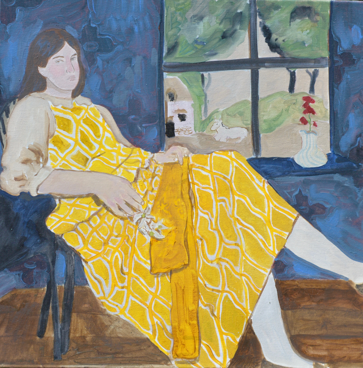A girl sitting in a chair in front of a window in a yellow dress. In her right hand she is holding three flannel flowers.