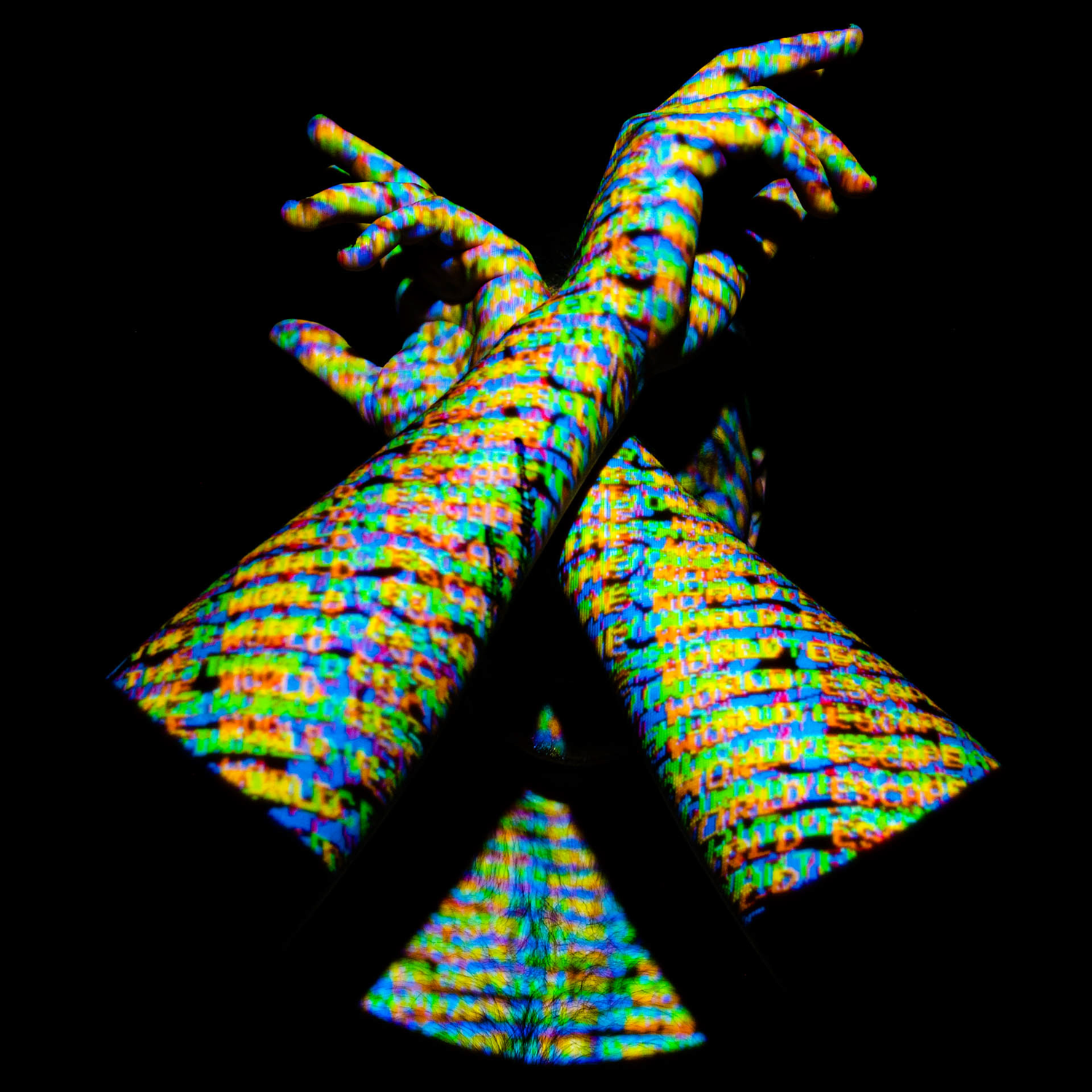 Colour image of a portrait of a man covering his face with crossed arms. Projected digital imagery covers his face and arms. The words "escape the world" are displayed on his skin.
