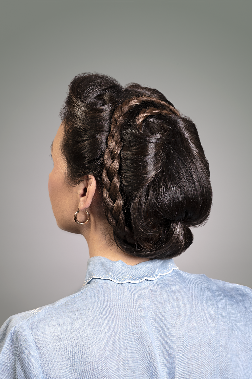 Feminine portrait photographed from behind with 1940s German Braid and high neck blue shirt. 