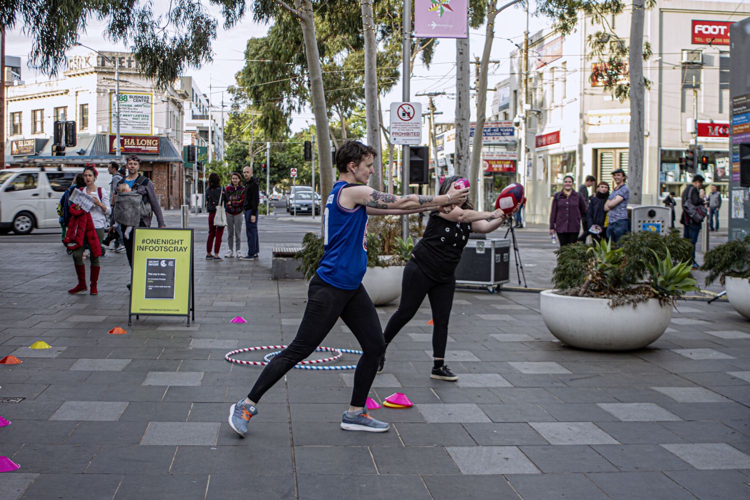 Two performers with painted AFL balls in Nicholson Street Mall