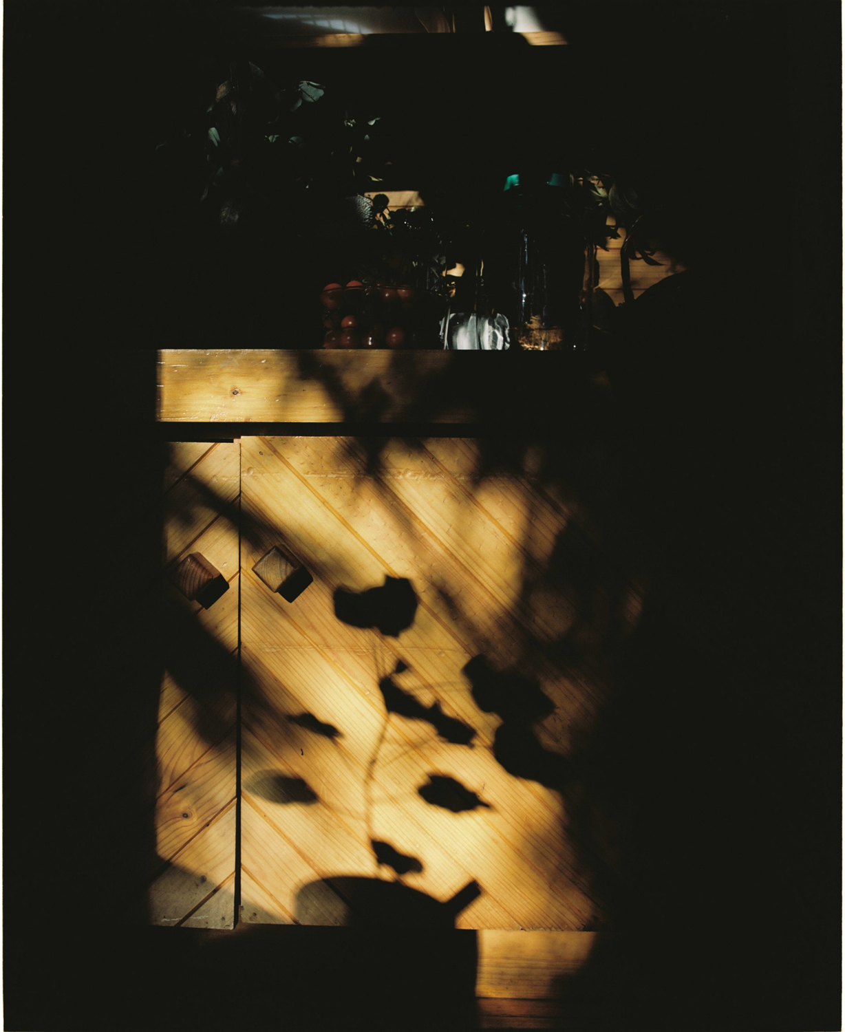 Colour photograph of shadows cast upon a kitchen bench.