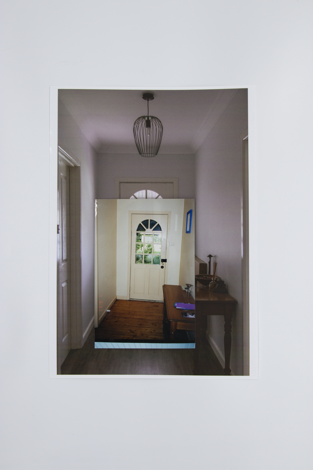 Coloured photograph depicting a domestic hallway leading to a front door. Photo is bordered by a secondary image of an empty domestic hallway leading to a front door.